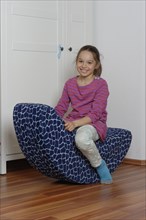 Girl on a child's rocking chair