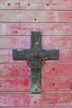 Weathered cross on a wooden wall