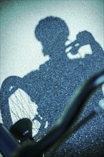 Shadow of man riding a bicycle on street