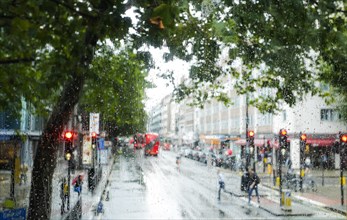 London street scene through rain-soaked bus windows