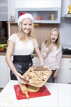 Girls making Christmas cookies at home