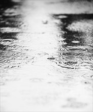 Water puddle with rain drops falling