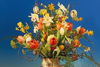 Easter bouquet in a vase against blue