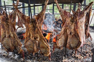 Spit-roasted mutton cooking on open fire