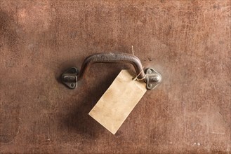 Handle and luggage tag of an old brown leather bag