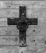 Weathered cross on a wooden wall