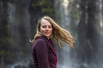 Young woman looks into the camera with waving hair