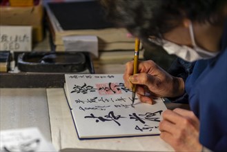 Woman writes Japanese characters
