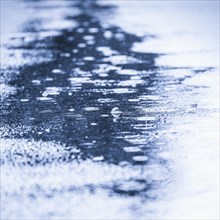 Water puddle with rain drops falling
