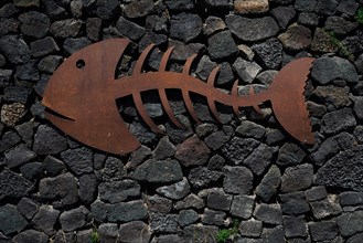 Metal fish on a stone wall