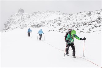Rope team in a storm during the ascent of Mt Schwarzenstein via the glacier