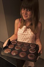 Girl presenting her homemade Oreo brownie cupcakes