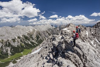 Hikers on the summit ridge during the ascent through the Imster via ferrata on the Maldonkopf in the Lech Valley Alps