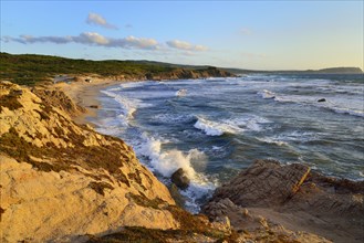 Coast with rocks and sandy beach in the evening light