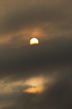 Sun behind clouds and brownish ash and gas clouds of the Holuhraun fissure eruption
