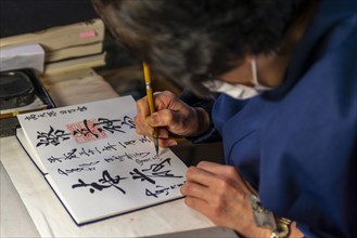Woman writes Japanese characters