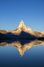 First sunlight on the Matterhorn with reflection in Stellisee lake