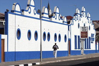 Local man walking in front of a colonial building