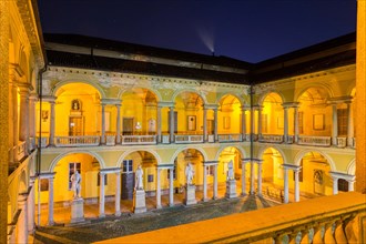 Illuminated courtyard with loggia and sculptures