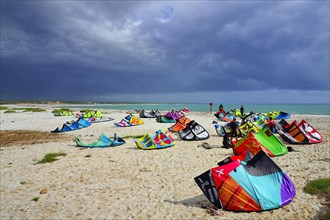 Kites and kitesurfers on the beach in high winds