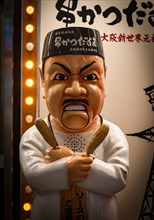 Figure of a Japanese cook in front of a restaurant
