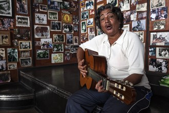 Female Cuban musician playing the guitar in a Casa de la Trova