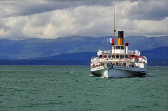 Paddle steamer Simplon on Lake Geneva or Lac Leman with storm clouds