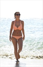 Young woman wearing a bikini coming out of the sea