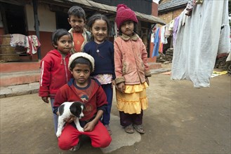 Nepalese children with little dog outside her house