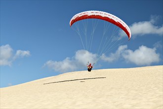 Paraglider taking off from the coast