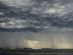 Five-master sailing ship in front of Crveni Vrh in thunderstorm atmosphere seen from Piran