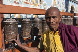 Monk turning prayer wheels