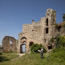 Man with map in front of the Burg Staufen castle ruins