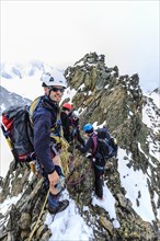 Mountaineers roped together on the summit ridge of the Aiguille du Genepi