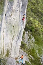 Freeclimber with helmet climbing on a rock face
