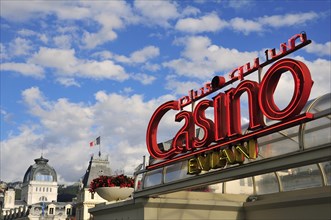 Neon sign of the Casino Evian in front of Town Hall and the Art Nouveau building of the Source Cachat