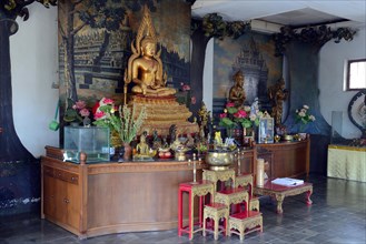 Buddha statue on an altar in a prayer hall of the Buddhist Brahma Vihara Monastery