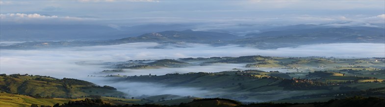 Maremma panorama view from Castiglioncello Bandini at sunrise with morning fog