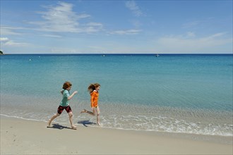 Children running on beach of Favone