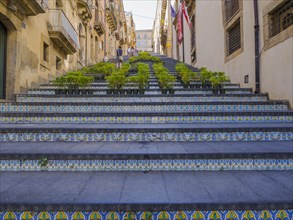 The Santa Maria del Monte staircase with ceramic tiles and potted plants