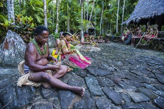 Traditionally dressed islanders making traditional art work