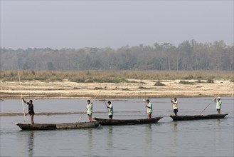 Nepalese men in dugouts on the East Rapti River at Sauraha