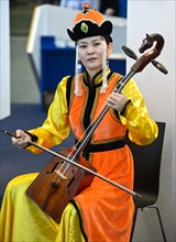 Mongolian musician is playing the horse-head fiddle or Morin Khuur