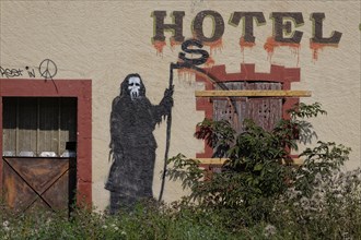 Abandoned hotel with graffiti of the Reaper