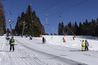 Skiers on a drag lift