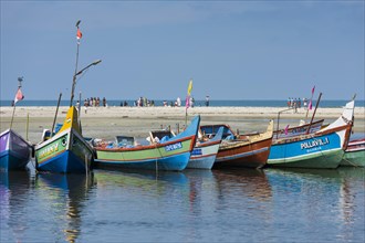 Brightly painted fishing boats and people on the beach