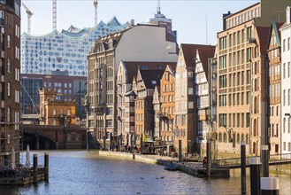 Old houses along the Nikolaifleet canal with under-construction Elbphilharmonie