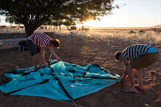 Two teenagers setting up a tent