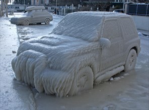 Car with a thick layer of ice parked in a street on Lake Geneva