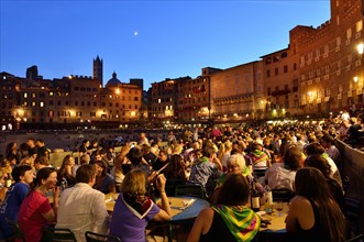Crowded tables of the restaurants on the track of the Palio di Siena after the race